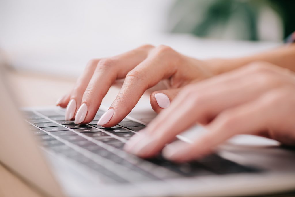 women typing on laptop