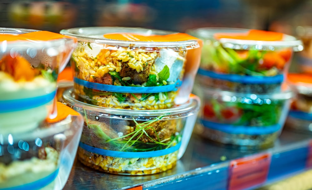 Packaged prepared meals in stacked food containers at a food manufacturing facility