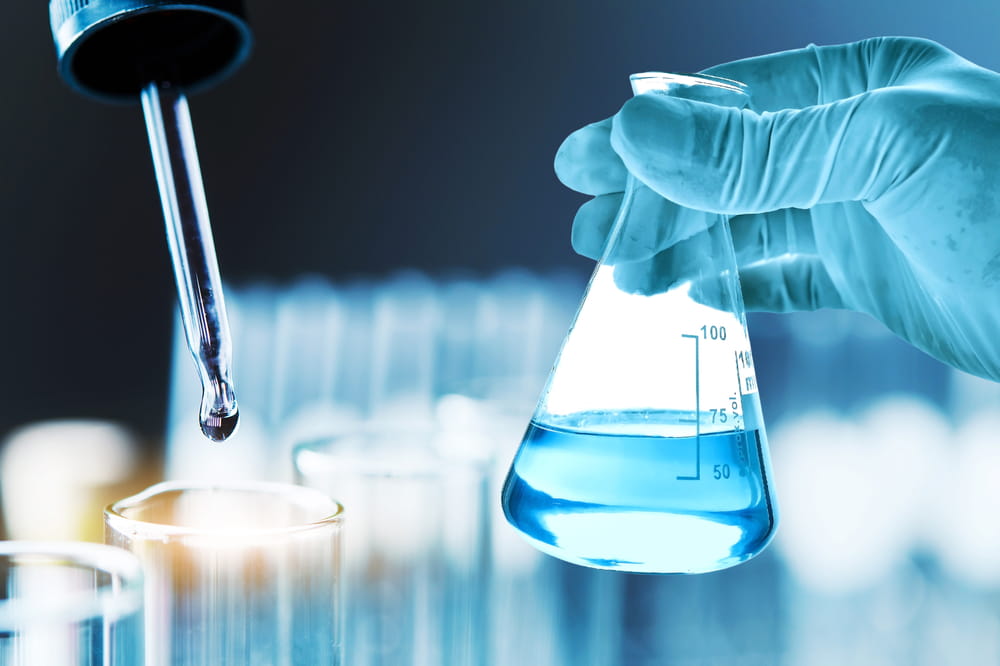 Laboratory technician handling chemical sample for quality control and testing